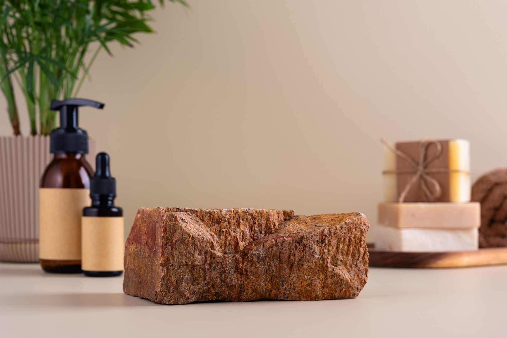 Natural beauty skincare product display featuring a rock centerpiece with eco-friendly bottles and handmade soap
